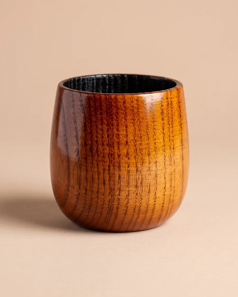 Houten whiskeyglas met glanzend zwart verkoold interieur, op een effen achtergrond