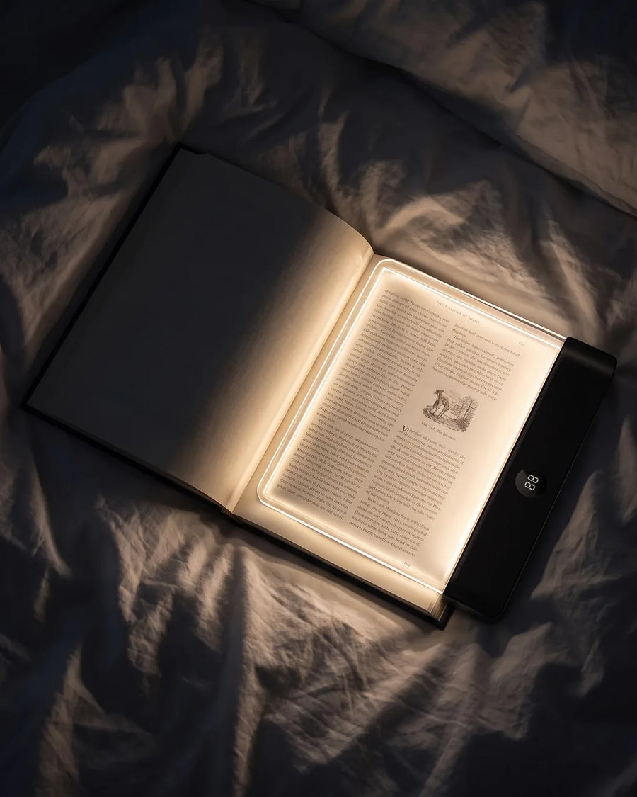 LED-leesplaat op een boek, gedimd licht in een donkere slaapkamer