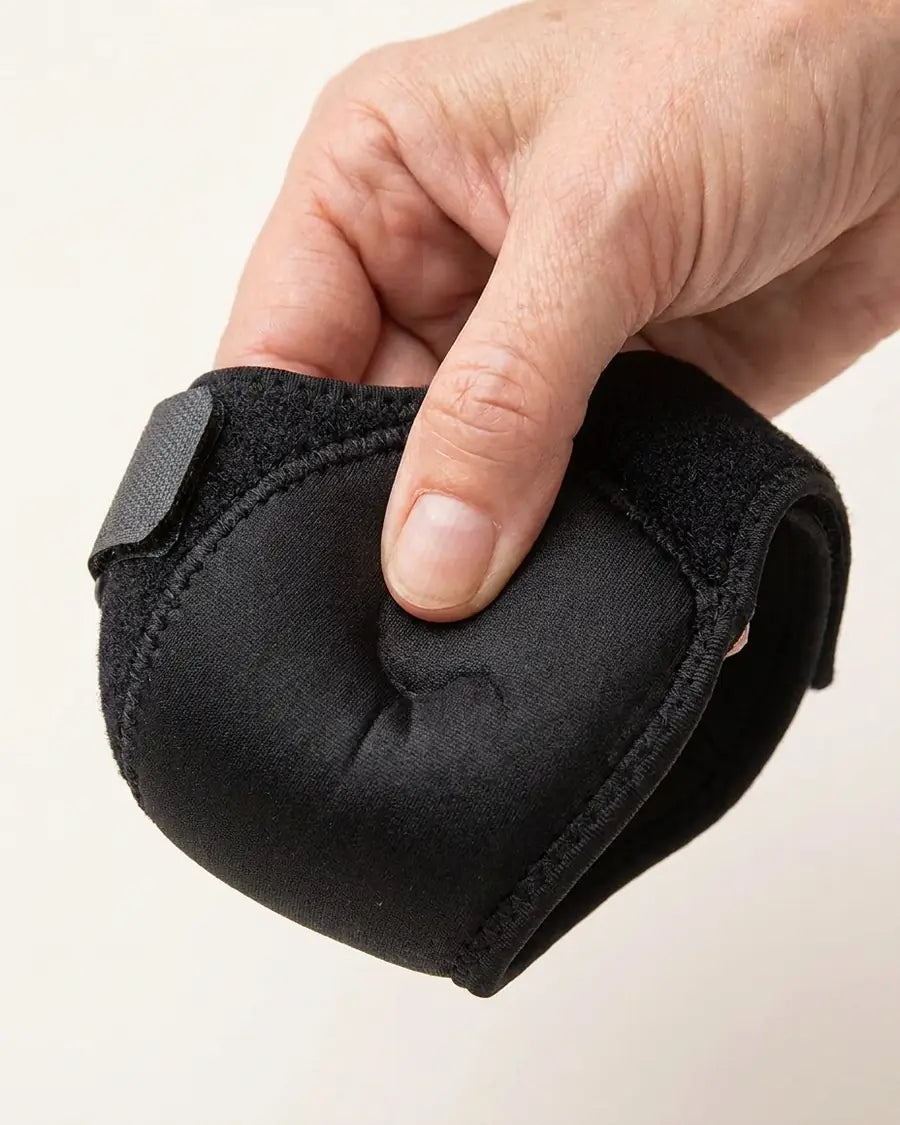 Duim drukt in het zachte hielkussen van de kap